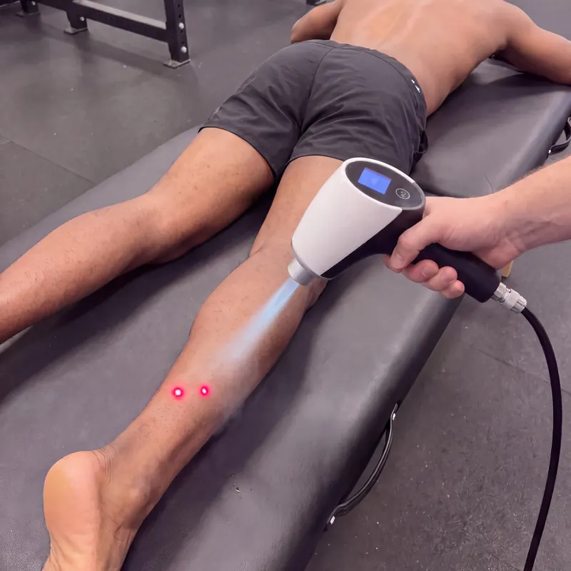 Red-light targeting dots on a runner's Achilles